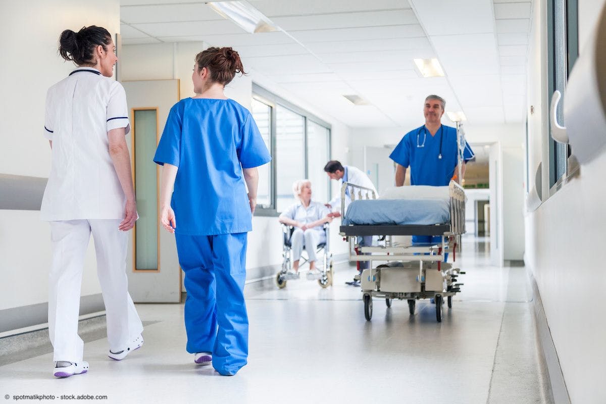 Male nurse pushing stretcher gurney bed in hospital corridor with doctors & senior female patient | Image Credit: © spotmatikphoto - stock.adobe.com