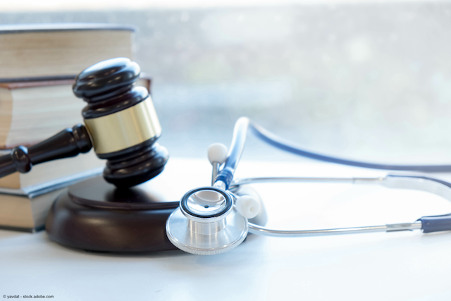 stacked books, gavel, and stethoscope lying next to each other on a table